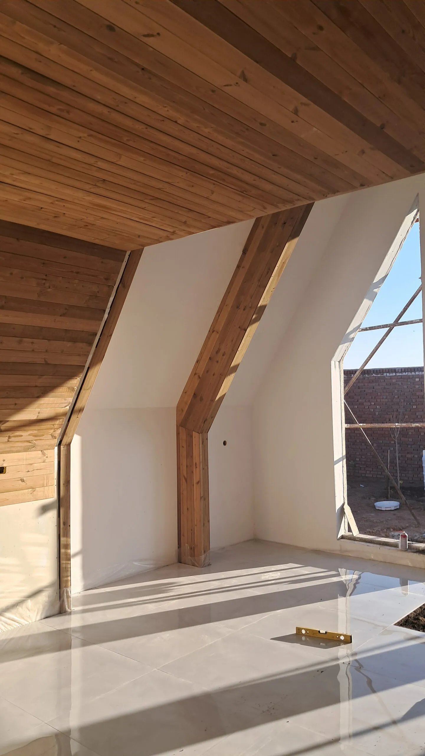فضای داخلی ویلای A-Frame با سقف چوبی و دیوارهای شیب‌دار